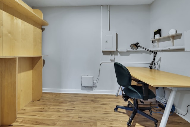 home office featuring electric panel and light hardwood / wood-style flooring