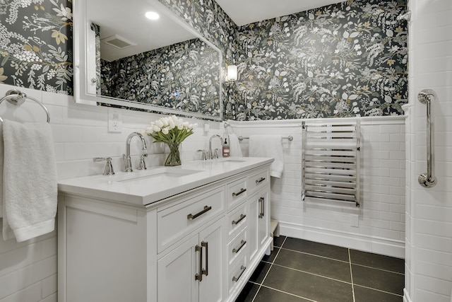 bathroom featuring tile patterned flooring, tile walls, dual vanity, and radiator heating unit