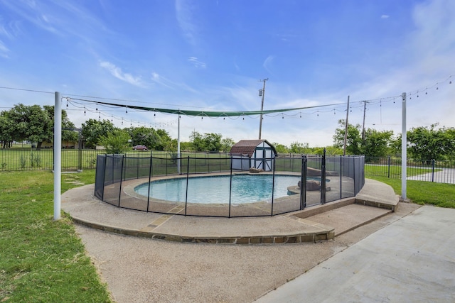 view of swimming pool featuring a lawn and a shed