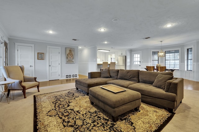 carpeted living room featuring ornamental molding