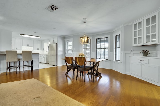 dining area featuring light hardwood / wood-style floors, a chandelier, and ornamental molding