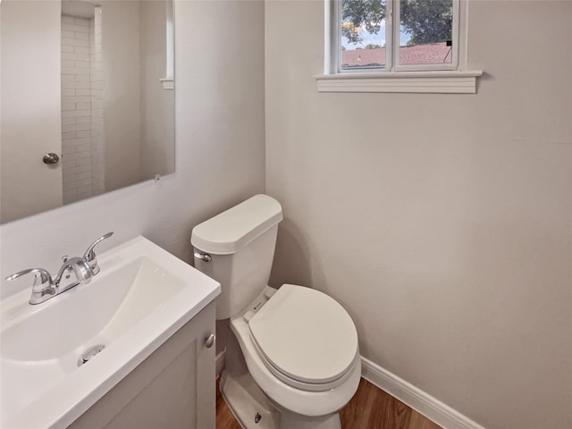 bathroom with hardwood / wood-style floors, toilet, and vanity