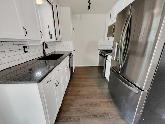 kitchen with white cabinetry, appliances with stainless steel finishes, dark hardwood / wood-style floors, sink, and tasteful backsplash