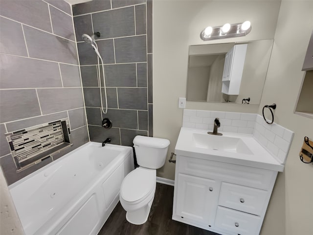 full bathroom with oversized vanity, tasteful backsplash, tiled shower / bath combo, hardwood / wood-style flooring, and toilet