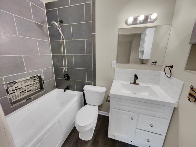 full bathroom with hardwood / wood-style floors, vanity, tasteful backsplash, toilet, and tiled shower / bath