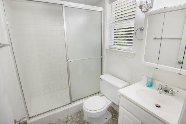 full bath with vanity, a shower stall, and toilet