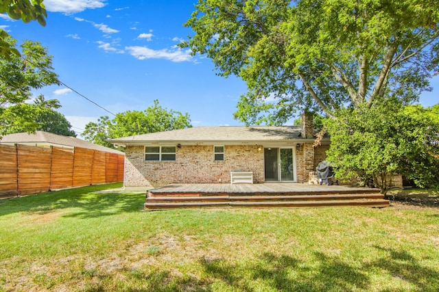 back of house featuring a wooden deck, a yard, brick siding, and fence