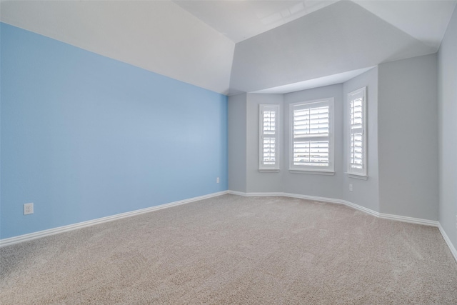 empty room featuring carpet floors and vaulted ceiling