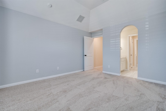 unfurnished room with light carpet and high vaulted ceiling