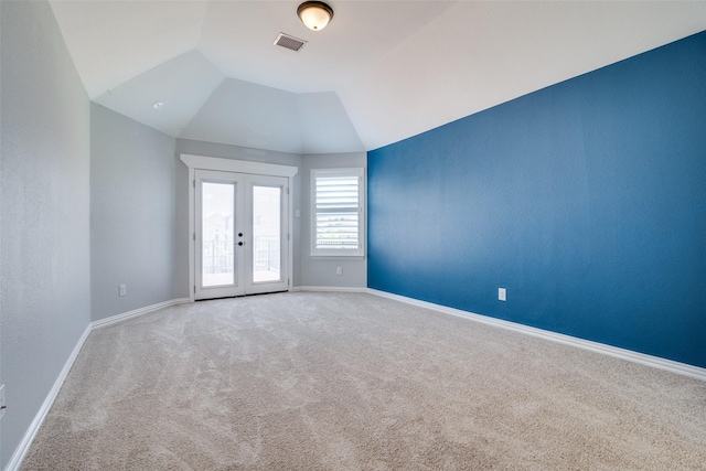 unfurnished room featuring carpet flooring, french doors, and vaulted ceiling