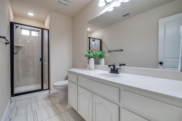 bathroom featuring vanity, a shower with shower door, and toilet