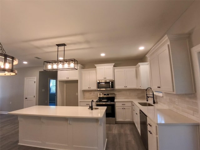 kitchen featuring white cabinetry, hanging light fixtures, a center island, and appliances with stainless steel finishes