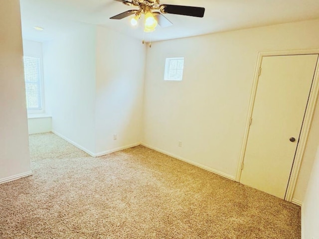 spare room featuring light colored carpet and ceiling fan