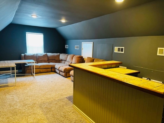 cinema room with carpet flooring and vaulted ceiling