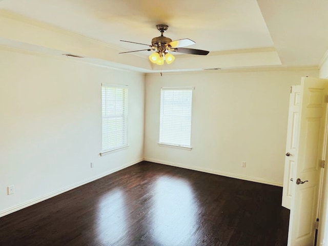 unfurnished room with a tray ceiling, ceiling fan, crown molding, and dark hardwood / wood-style floors