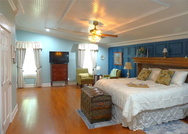 bedroom featuring ceiling fan, multiple windows, hardwood / wood-style flooring, and crown molding