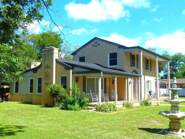 rear view of house featuring a lawn