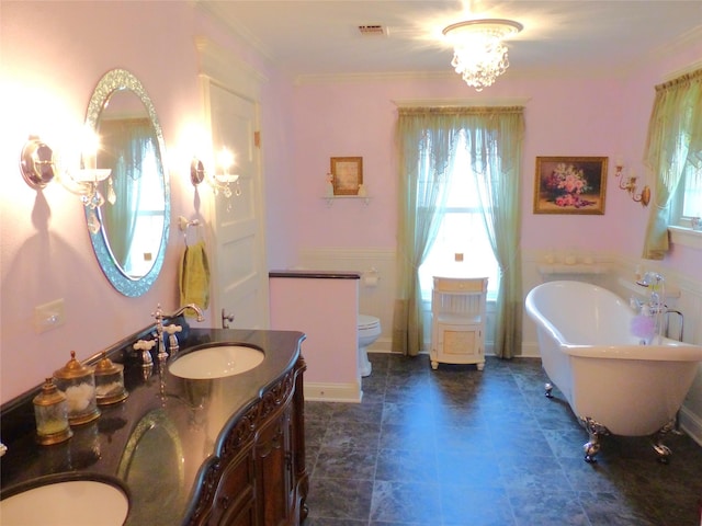 bathroom with toilet, vanity, a bathing tub, and an inviting chandelier