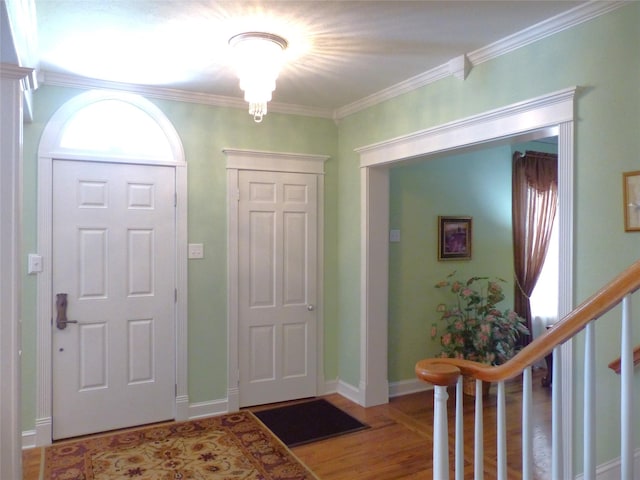 entryway featuring a wealth of natural light, ornamental molding, and hardwood / wood-style flooring