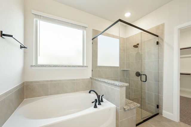 bathroom featuring tile patterned flooring and plus walk in shower