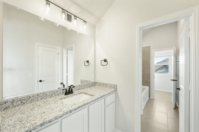 bathroom with vanity, vaulted ceiling, and tile patterned flooring