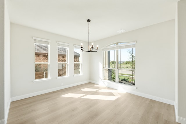 unfurnished dining area featuring a notable chandelier and light hardwood / wood-style floors