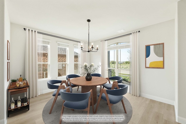 dining space featuring light hardwood / wood-style flooring and an inviting chandelier