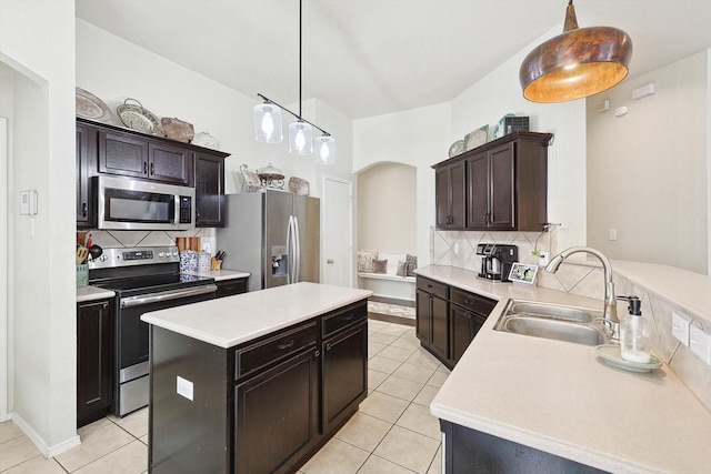 kitchen featuring appliances with stainless steel finishes, sink, light tile patterned floors, dark brown cabinetry, and kitchen peninsula