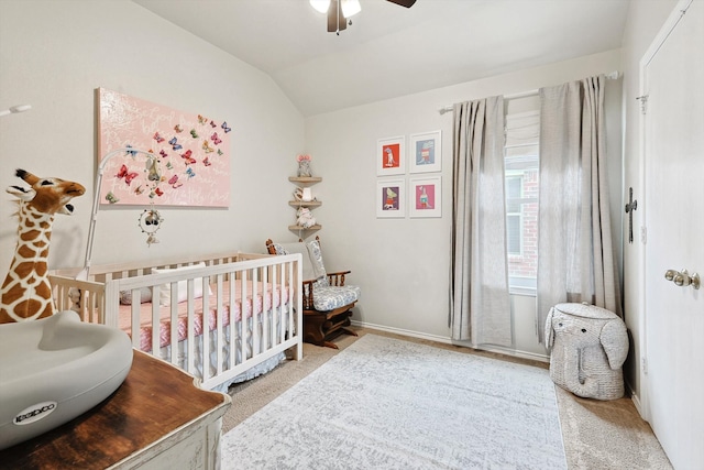 bedroom featuring baseboards, a crib, a ceiling fan, and vaulted ceiling