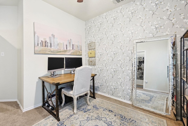 carpeted home office featuring visible vents, wallpapered walls, baseboards, and a ceiling fan