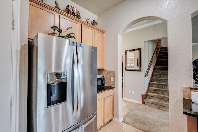 kitchen with stainless steel refrigerator with ice dispenser, light brown cabinets, tasteful backsplash, and light tile patterned floors