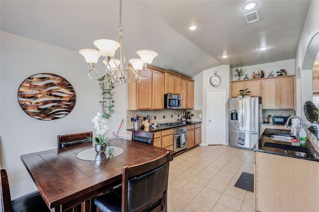 kitchen with light brown cabinets, lofted ceiling, sink, appliances with stainless steel finishes, and tasteful backsplash