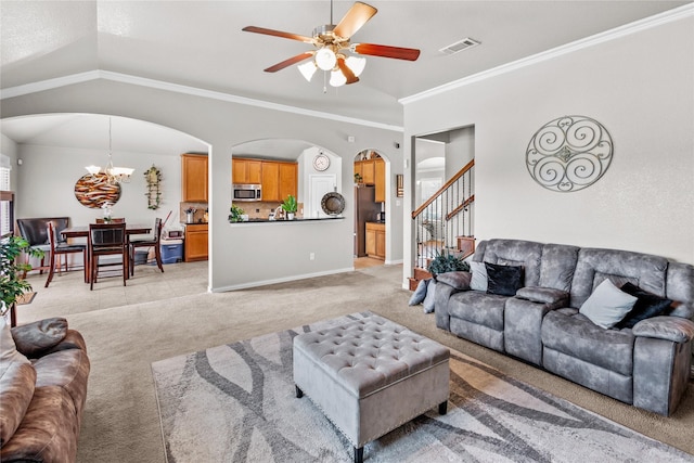 living room featuring light carpet, lofted ceiling, ceiling fan with notable chandelier, and crown molding