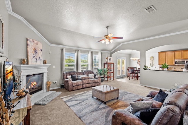 living room featuring a textured ceiling, light carpet, ceiling fan with notable chandelier, and lofted ceiling