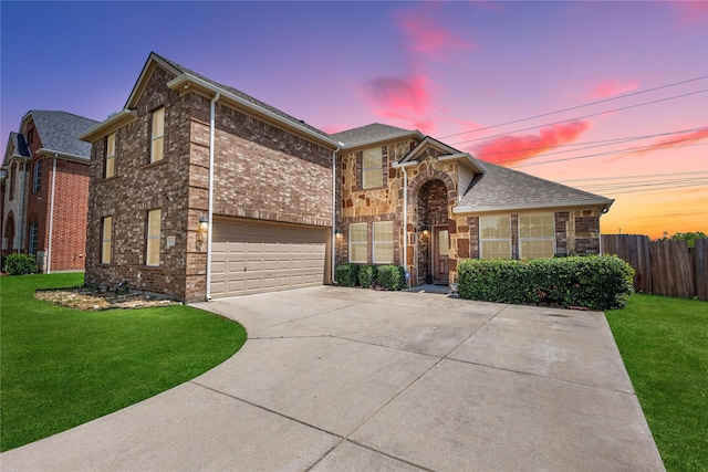 view of front of property featuring driveway, a garage, fence, and a front lawn