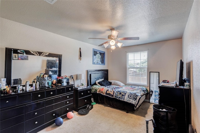 carpeted bedroom featuring a textured ceiling and ceiling fan