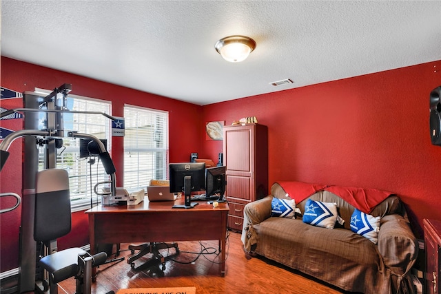 home office featuring hardwood / wood-style floors and a textured ceiling