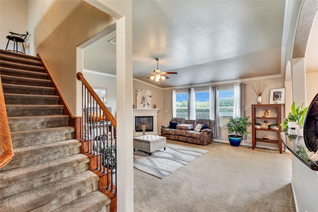 carpeted living room featuring a textured ceiling, ceiling fan, and crown molding