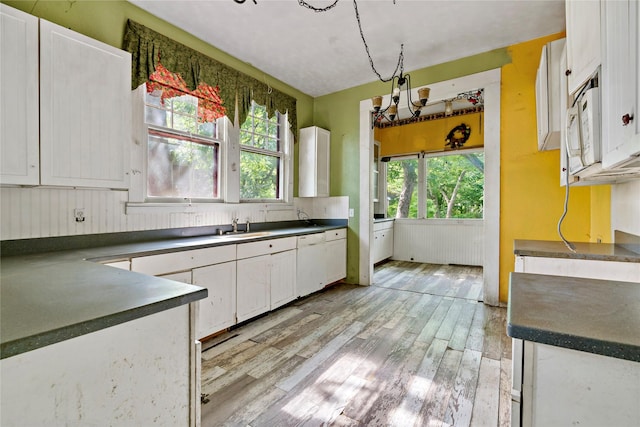 kitchen featuring white appliances, a healthy amount of sunlight, and white cabinets