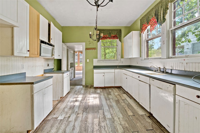 kitchen featuring plenty of natural light, a chandelier, light hardwood / wood-style floors, and white dishwasher