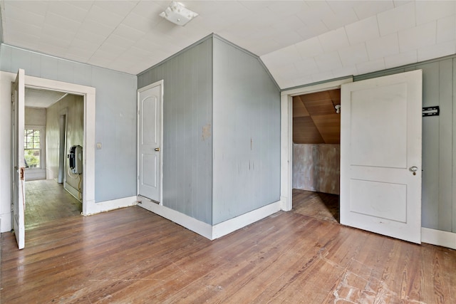 unfurnished bedroom featuring wood-type flooring and vaulted ceiling