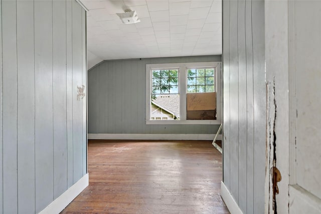 bonus room with lofted ceiling, wood-type flooring, and wood walls