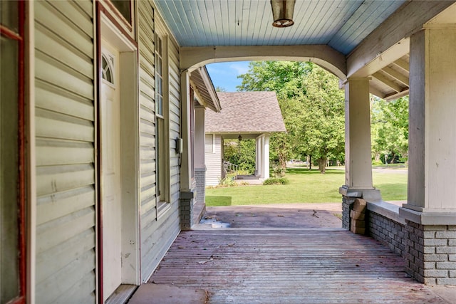 wooden deck with a porch and a lawn