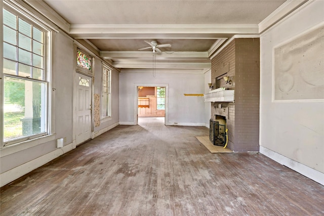 unfurnished living room featuring crown molding, ceiling fan, beam ceiling, wood-type flooring, and a brick fireplace