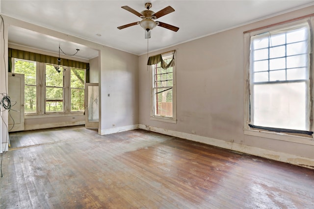 empty room featuring ceiling fan, hardwood / wood-style flooring, and crown molding