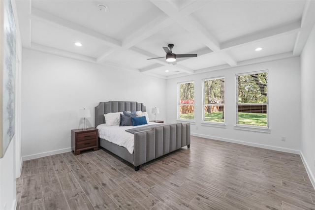 bedroom featuring ceiling fan, beamed ceiling, light hardwood / wood-style floors, and coffered ceiling