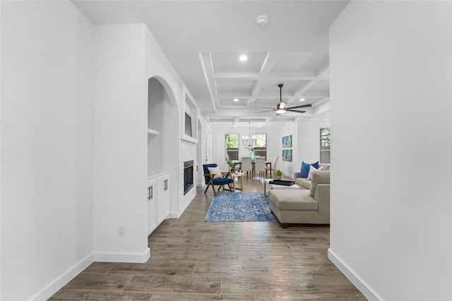 living room with beam ceiling, ceiling fan, coffered ceiling, a fireplace, and hardwood / wood-style flooring