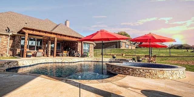 view of swimming pool with a patio area, a yard, an in ground hot tub, and pool water feature