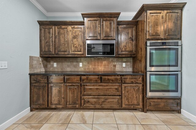 kitchen with dark stone countertops, stainless steel appliances, dark brown cabinets, decorative backsplash, and ornamental molding