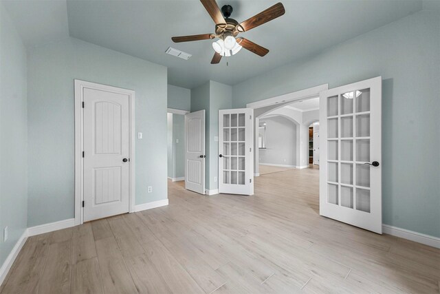 empty room featuring french doors, light hardwood / wood-style flooring, and ceiling fan